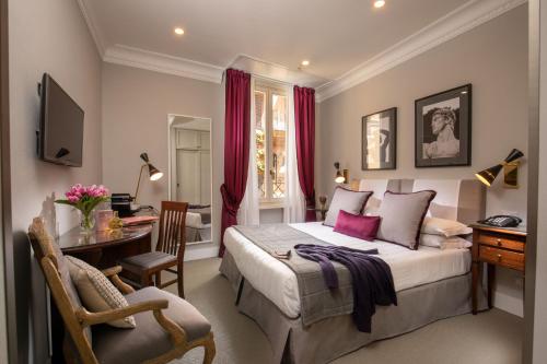 um quarto com uma cama king-size, uma secretária e uma cadeira. em Condotti Boutique Hotel em Roma