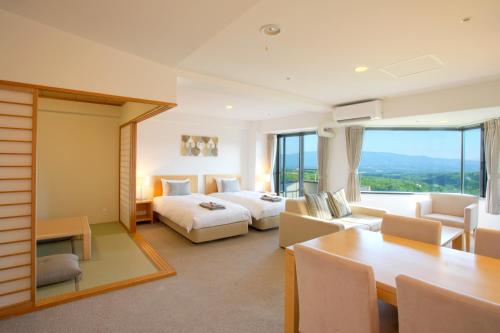 a hotel room with two beds and a table at One Niseko Resort Towers in Niseko