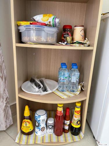 a shelf with bottles of water and other items in a refrigerator at Alhosani property in Abu Dhabi