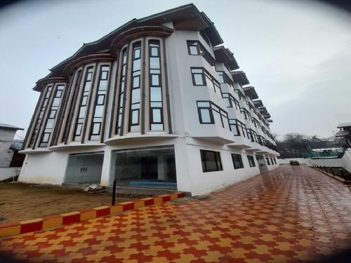 a large white building with a lot of windows at Hotel Zoon Dabb Srinagar airport kashmir in Srinagar