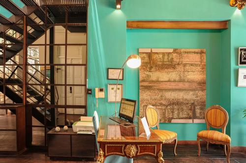 a room with a green wall and a desk with a laptop at San Telmo Suites in Buenos Aires