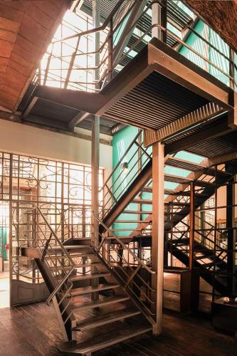 a wooden spiral staircase in a building with a window at San Telmo Suites in Buenos Aires