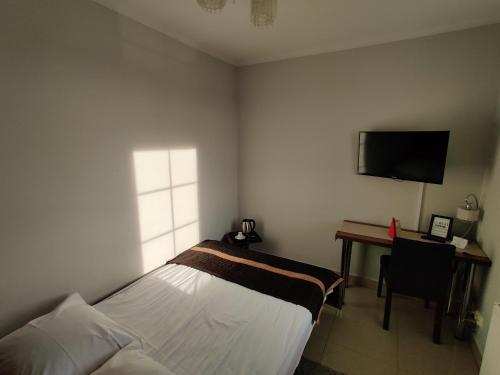 a bedroom with a bed and a desk and a television at Belweder in Białystok