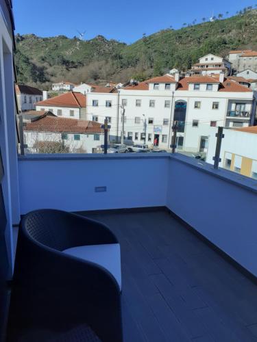 a balcony with a couch and a view of a city at Beecaramulo-Apiturismo in Caramulo
