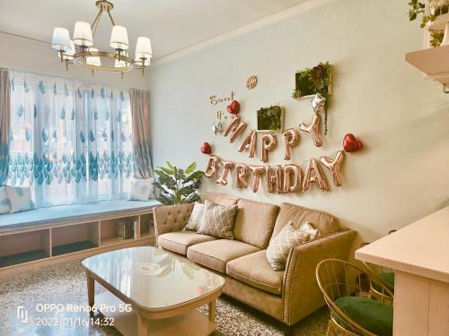 a living room with a couch and a happy birthday sign at 小院子4人至6人包棟民宿 in Taitung City