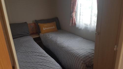 two beds in a small room with a window at The Chase Ingoldmells in Ingoldmells