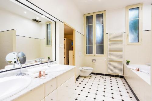 une salle de bain avec deux lavabos et un WC dans l'établissement Villa la Pescade by Riviera Holiday Homes VI4257, à Nice
