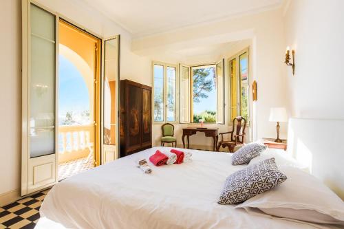 - une chambre avec un grand lit blanc et un balcon dans l'établissement Villa la Pescade by Riviera Holiday Homes VI4257, à Nice