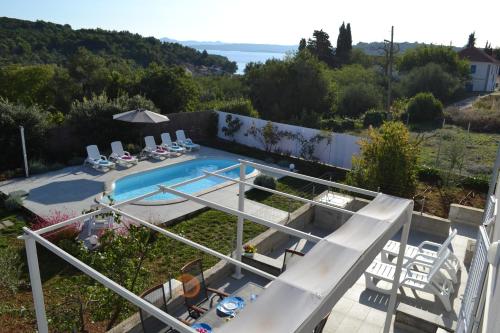 a view of a swimming pool with chairs and avisor at holiday home on DUGI OTOK - OTOK in Brbinj