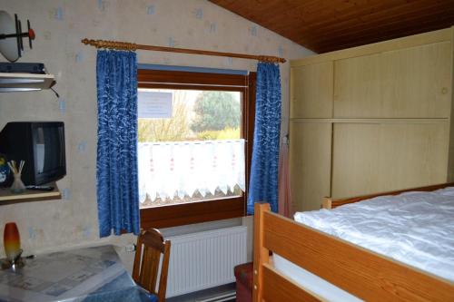 SimonsbergにあるHaus-Sonneneckのベッドルーム1室(ベッド1台、青いカーテン付きの窓付)