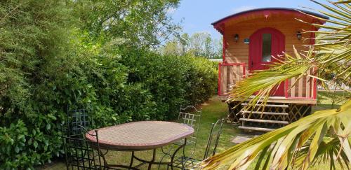 - une table de pique-nique devant une maison ornithologique dans l'établissement LE PETIT NID DANS LA ROULOTTE, à Roscanvel