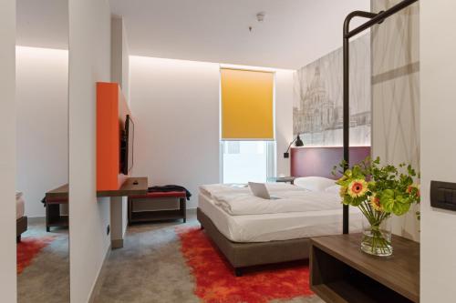 a bedroom with a bed and a vase of flowers at Campanile Venice Mestre in Mestre