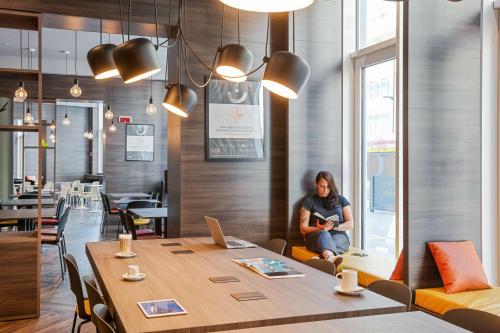 a woman sitting at a table in a restaurant at Campanile Venice Mestre in Mestre