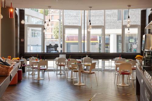 a restaurant with tables and chairs and windows at Campanile Venice Mestre in Mestre