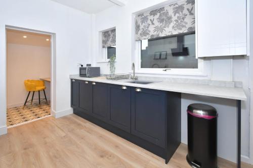 a kitchen with a sink and a counter top at Elm House by YourStays - Lovely home in Cheshire, quiet residential street in Crewe