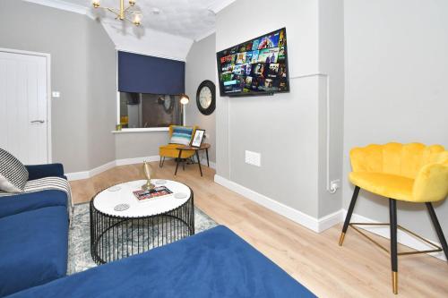 a living room with a blue couch and a yellow chair at Elm House by YourStays - Lovely home in Cheshire, quiet residential street in Crewe