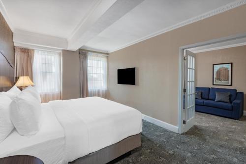 a bedroom with a white bed and a blue couch at The Americus Hotel, Trademark Collection by Wyndham in Allentown