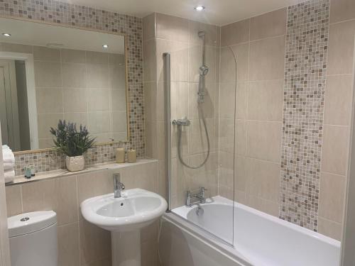 a bathroom with a sink and a shower and a tub at Kintyre Apartment in Ayr