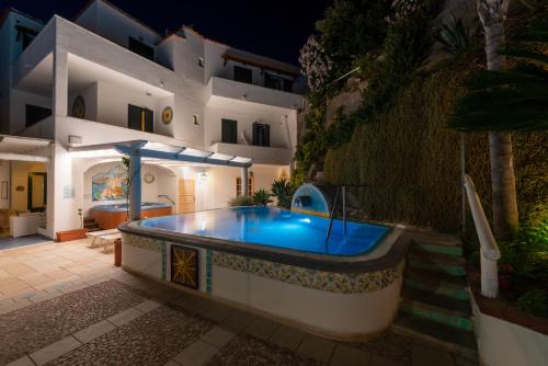 a pool in front of a house at night at Hotel Villa Bianca in Ischia