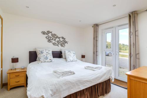 a bedroom with a large bed and a window at Beach Retreat - Mount Brioni in Downderry