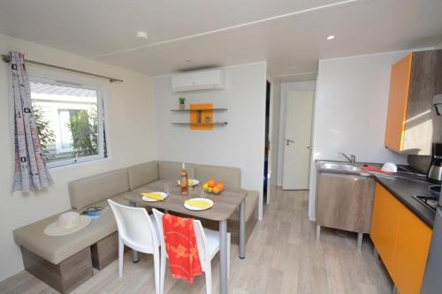 a kitchen and a dining room with a table in a kitchen at Camping Parc Mogador in Sanary-sur-Mer