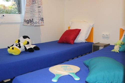 a bedroom with two beds with stuffed animals on them at Camping Parc Mogador in Sanary-sur-Mer