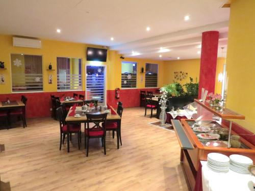 a dining room with tables and chairs in a restaurant at ates Hotel Lampertheim in Lampertheim