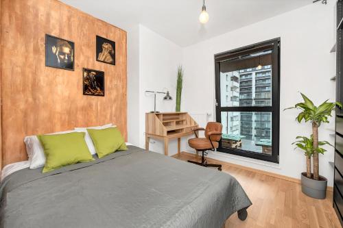a bedroom with a bed and a desk and a window at Lumina 4-room apart with large balcony in Warsaw