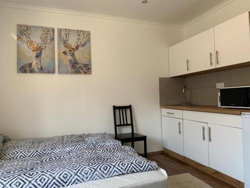 sypialnia z łóżkiem i dwoma obrazami na ścianie w obiekcie Alfa Apartman w mieście Sátoraljaújhely