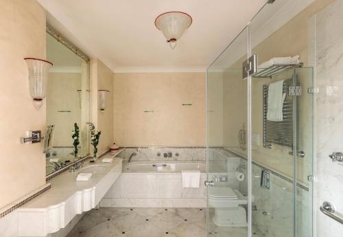a bathroom with a tub and a toilet and a shower at Hotel Cipriani, A Belmond Hotel, Venice in Venice