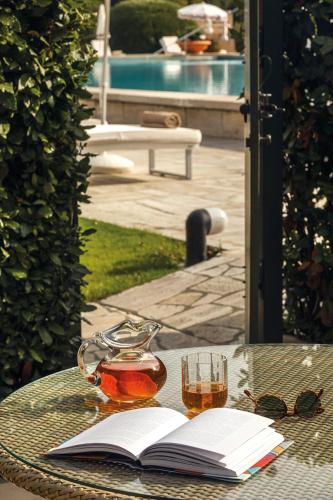a table with a book and a glass of tea and an open book at Hotel Cipriani, A Belmond Hotel, Venice in Venice