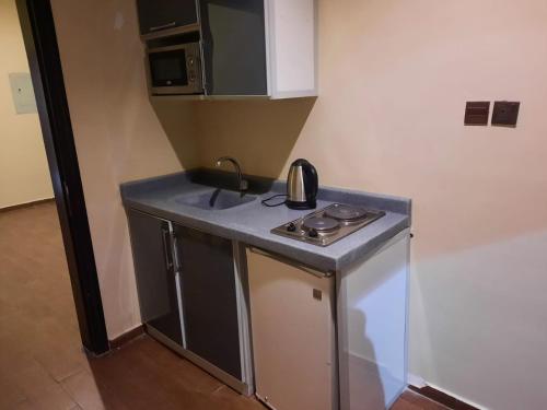 a small kitchen with a sink and a stove at شقق درر رامه للشقق المخدومة 12 in Riyadh