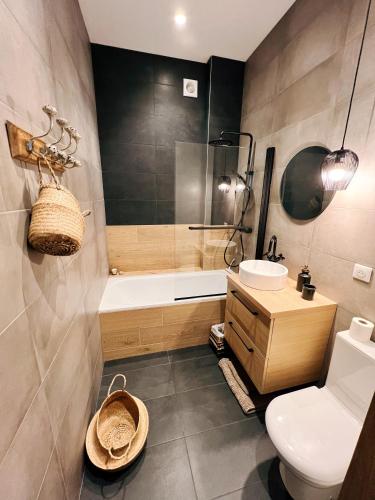 une salle de bain avec toilettes, baignoire et lavabo dans l'établissement Le Belleville, proche hypercentre au calme, wifi, à Nantes
