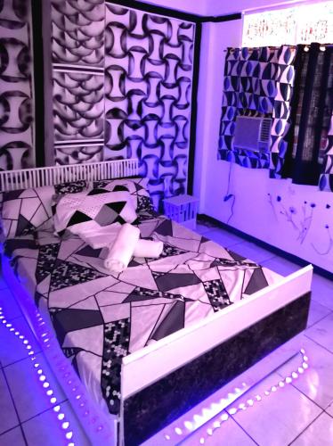 a bedroom with a bed with purple lights at Cabanatuan CIty PNY TRANSIENT INN 1 in Cabanatuan