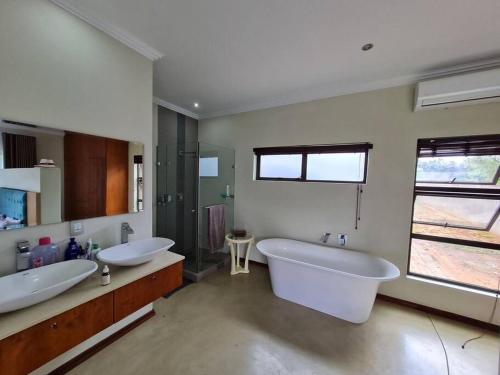a large bathroom with two sinks and a large tub at No 16 Elements - 5 Bedroom Beauty in Moheme