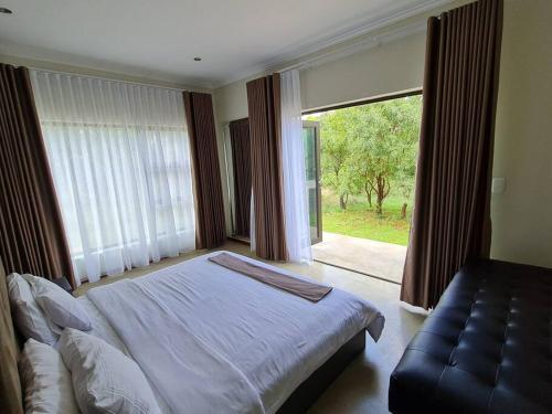 a bedroom with a bed and a large window at No 16 Elements - 5 Bedroom Beauty in Moheme