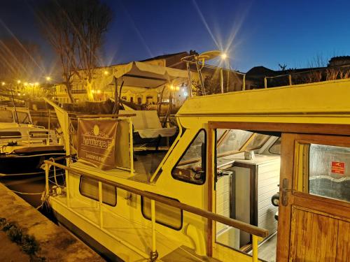 a yellow boat parked in a marina at night at Bateau Fellowship in Narbonne