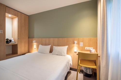 Un pat sau paturi într-o cameră la The Originals Access Hôtel Bordeaux Aéroport