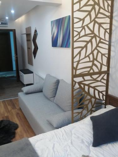a living room with a couch and a geometric wall at President KOP A515 in Kopaonik