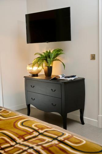 a black dresser with a tv on top of it at Bubble 8 in Épernay