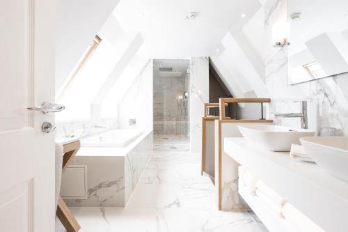 a white bathroom with two sinks and mirrors at The Scotsman Hotel in Edinburgh