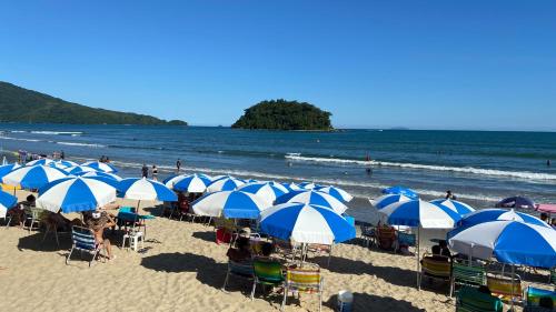 a bunch of blue and white umbrellas on a beach at Kaliman Pousada in Ubatuba