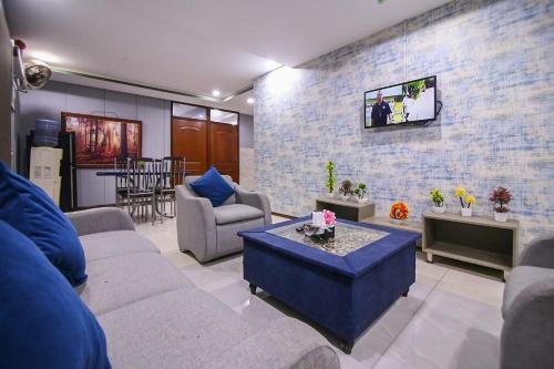 a living room with couches and a tv on a brick wall at Two Bedrooms Apartment Near DHA & Airport in Lahore