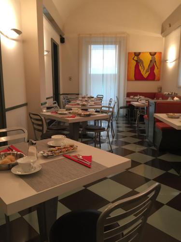 um restaurante com mesas e cadeiras num quarto em Hotel Tirrenia em Viareggio