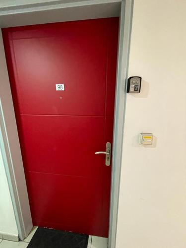a red door with a sign on it in a room at Superbe studio en bord de mer in Saint-Pierre