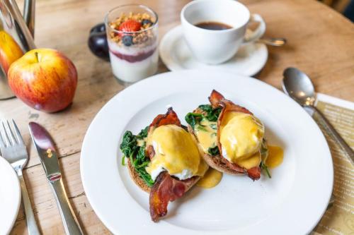 a white plate with breakfast food and a cup of coffee at Brooks Guesthouse Bristol in Bristol