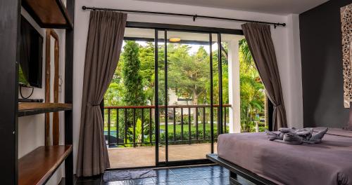 a bedroom with a bed and a large glass door at Aqua Suites in Wok Tum