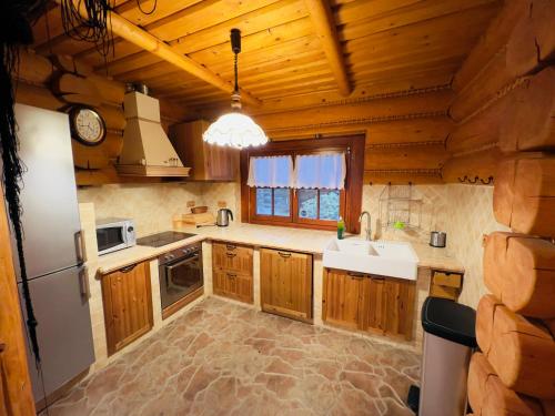 a kitchen with wooden cabinets and a sink and a refrigerator at Dom góralski Kasinka in Kazuń Bielany