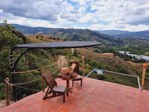 a patio with two chairs and a table with a view at Paraiso de Arcilla - Suite & Glamping in Ráquira