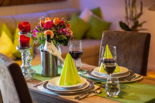 a table with plates and glasses of wine and flowers at Ferienwohnung Hörndlwand Ruhpolding in Ruhpolding